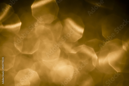 Abstract gold glitter lights on golden background. Round defocused circles bokeh and shine glitters bright light. Template for design