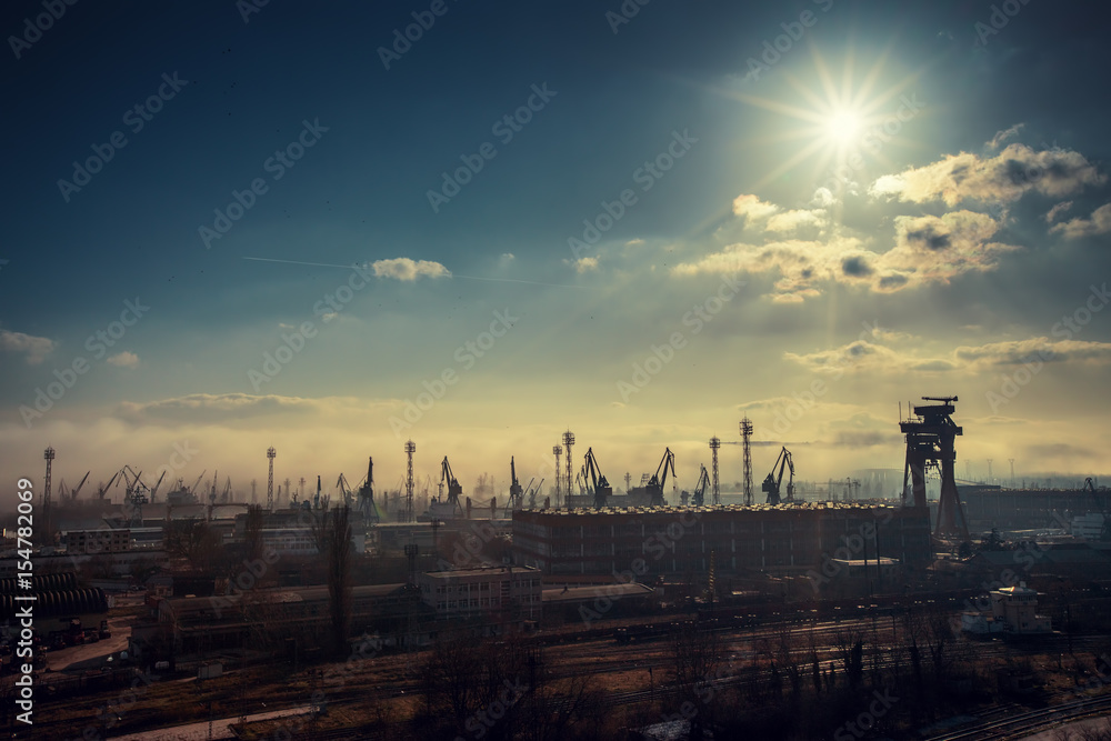 Panoramic view toward sea port and industrial cranes