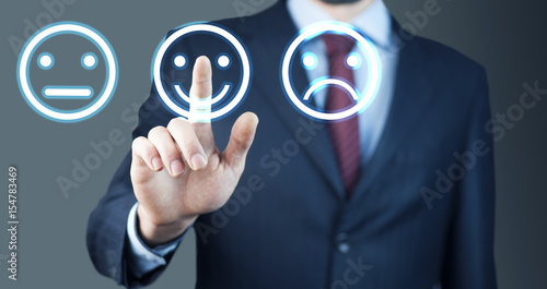 Businessman hand pointing the smiley face icon from screen