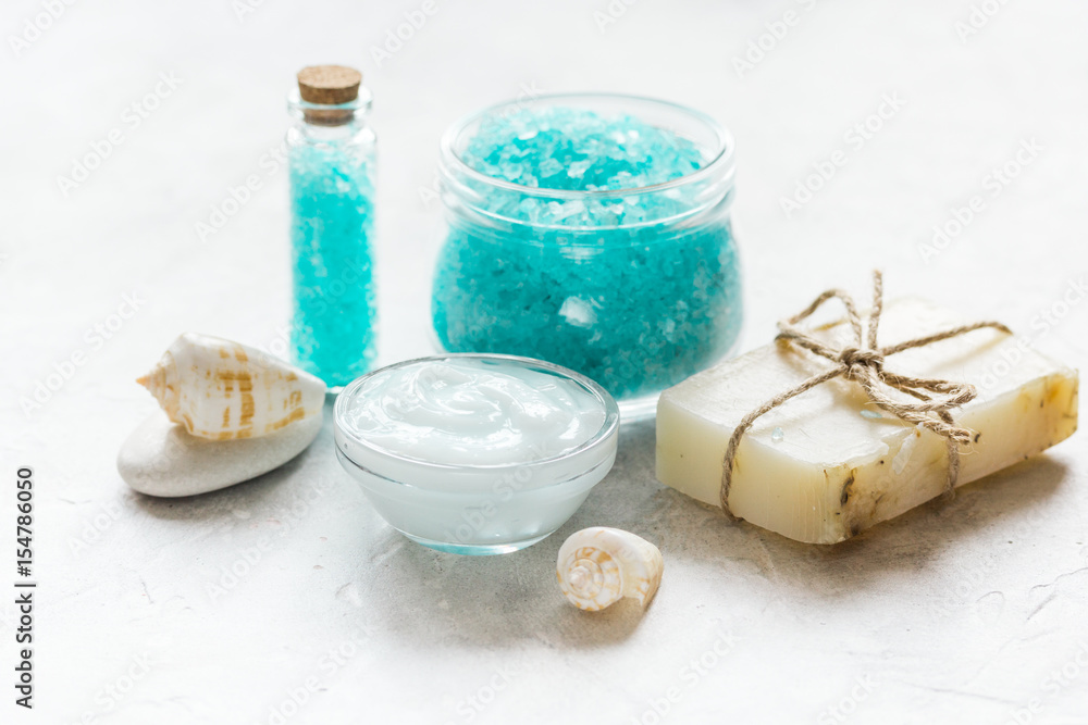 set for bath with blue salt and shells on stone table background set for bath with blue salt and shells on stone table background