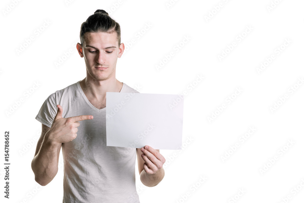 A young handsome guy with a blank sheet of paper looking at a sheet. Place for signature, text. Horizontal frame A young handsome guy with a blank sheet of paper looking at a sheet. Place for signature, text. Horizontal frame