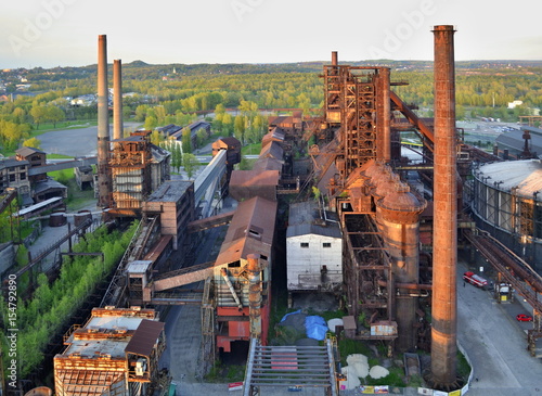 Abandoned ironworks factory with forest in the background