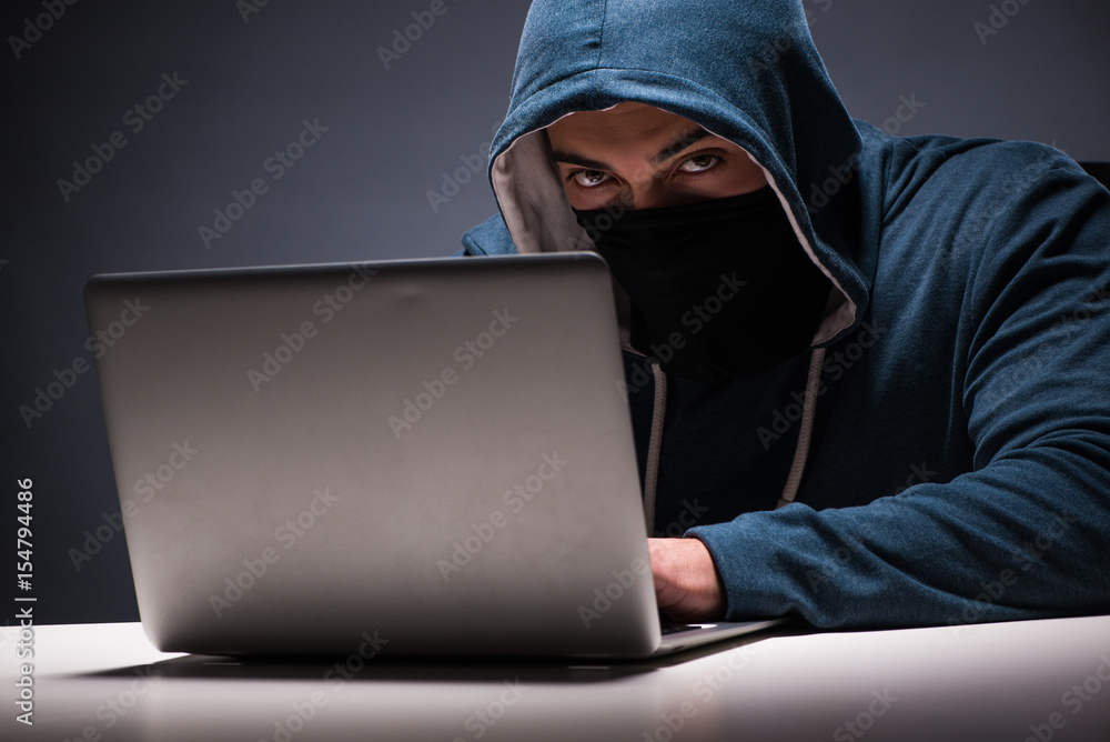 Computer hacker working in dark room Computer hacker working in dark room