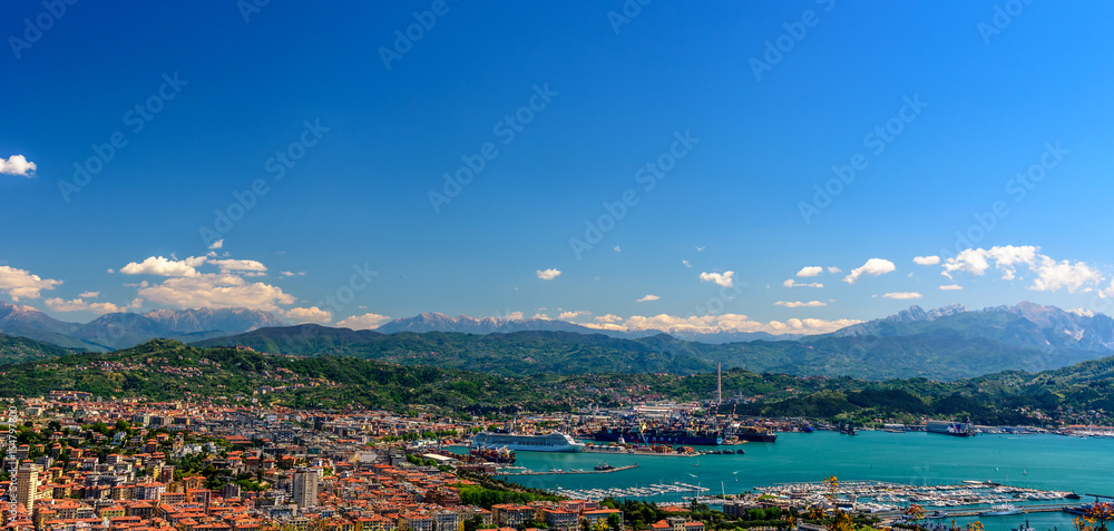Aerial view of the port an the city of La Spezia with boats and mountains at the horizon.