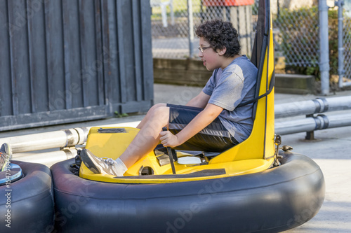 Boy in amusement park bumper car ride, end of car rising up © Rachel Lerch