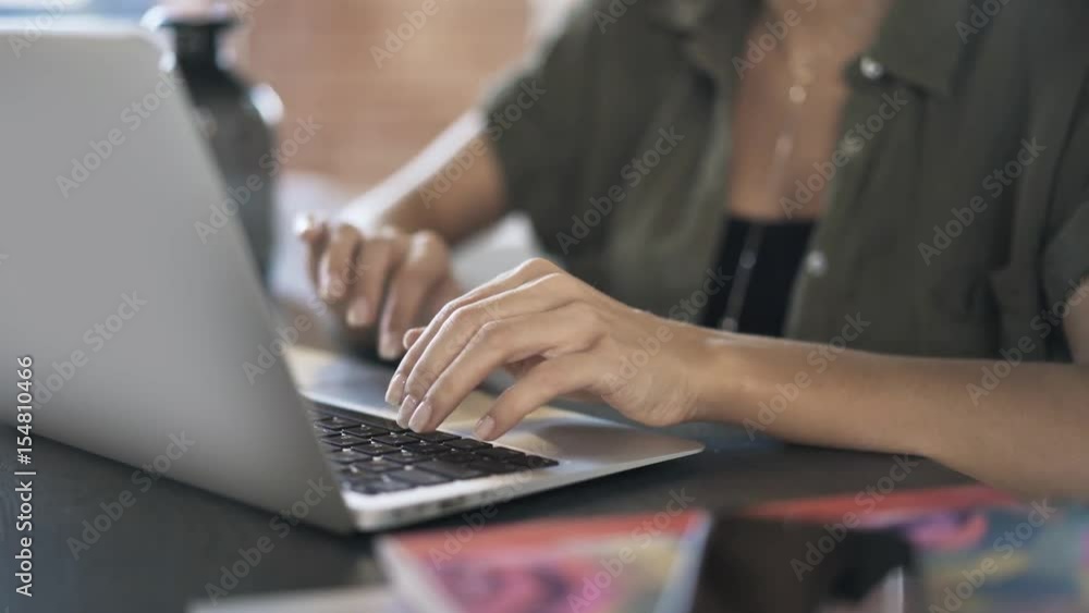 Close up of woman s hands typing at her laptop keyboard and using a touchpad in an office. Right to left pan real time close up shot Close up of woman s hands typing at her laptop keyboard and using a touchpad in an office. Right to left pan real time close up shot
