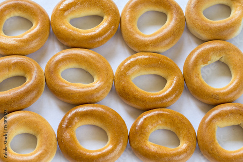 A lot of baked bagels in a raw on white background