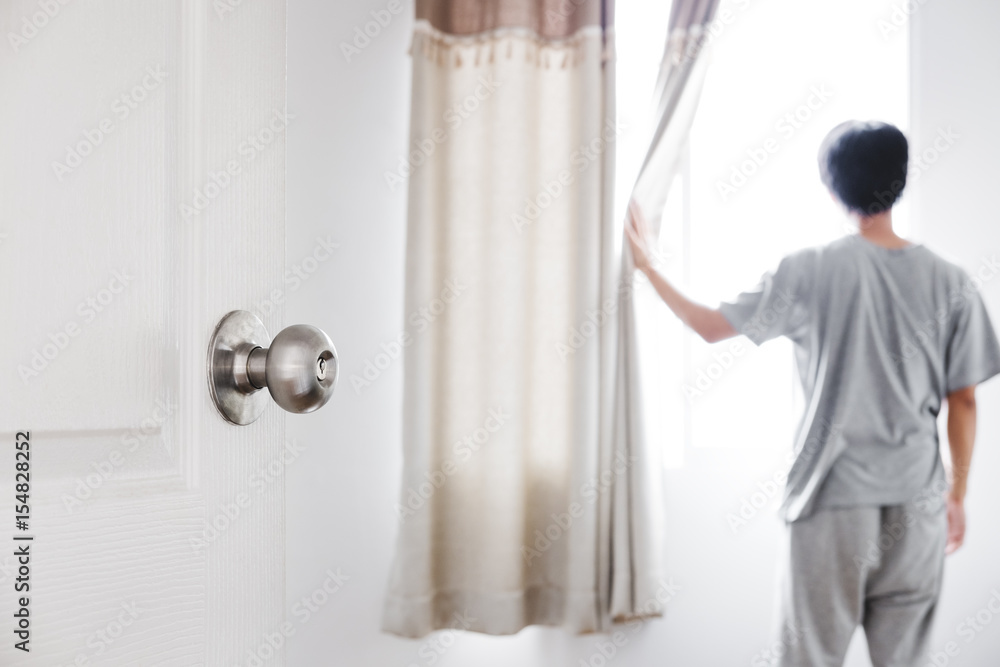 Φωτογραφία Door opened to the room, with a man open curtain  receiving sunlight in the morn