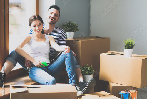 Couple moving in house sitting on the floor