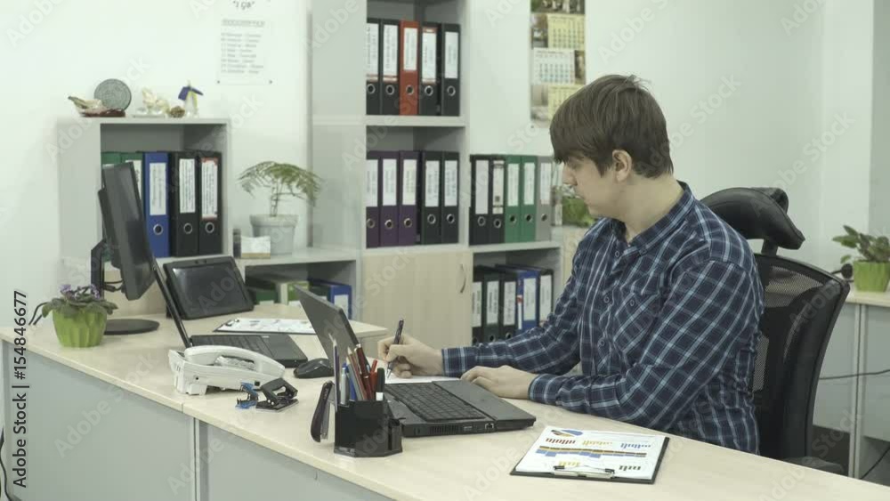 It Programmer Are Working On Computers In A Bright Office Room. Office Worker It Programmer Are Working On Computers In A Bright Office Room. Office Worker