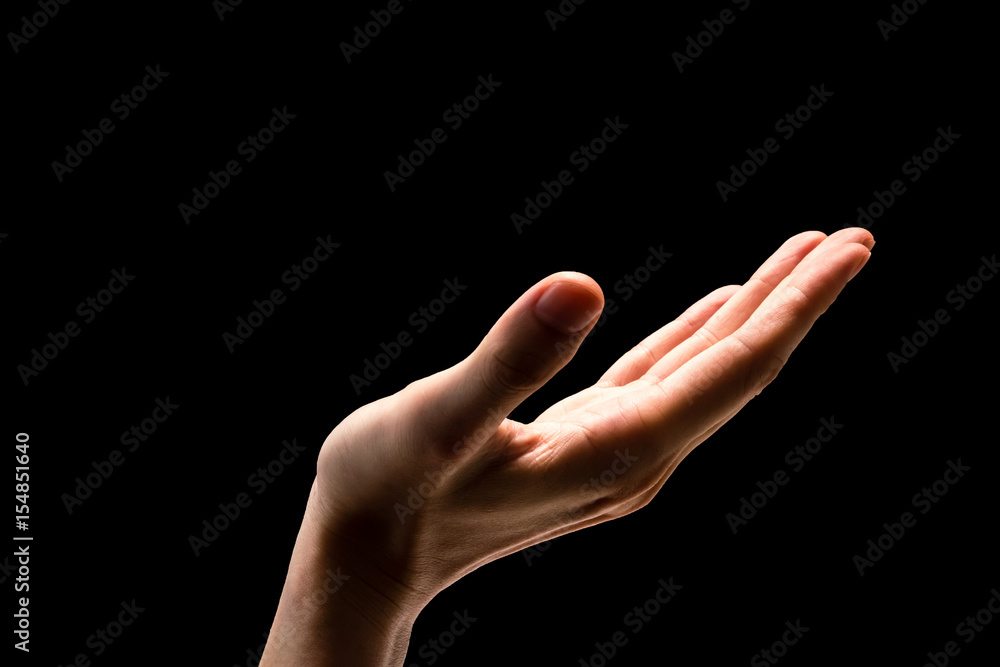 Male hand on a black background.