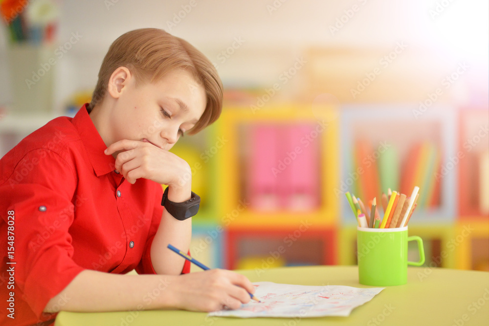 Cute boy drawing with pencils