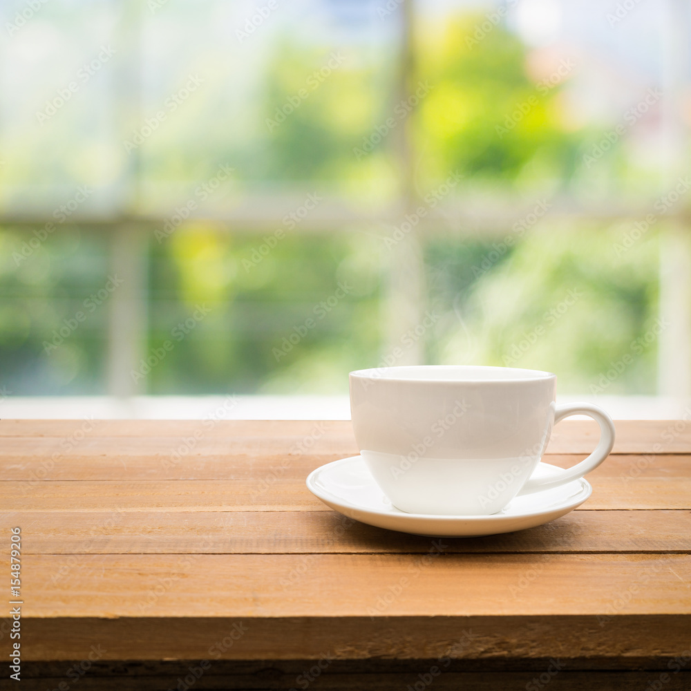 Cup of coffee on table with garden in morning