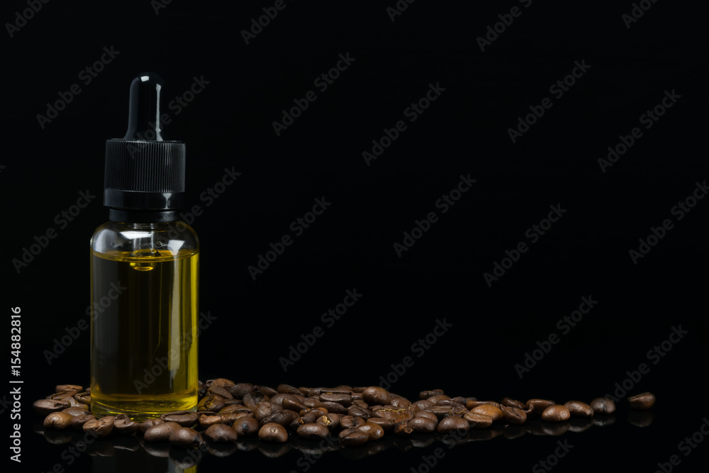 bottle with the aroma of coffee stands in beans on a black background bottle with the aroma of coffee stands in beans on a black background