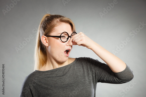 Obraz na plátně Girl pinches her nose because of stench stink.