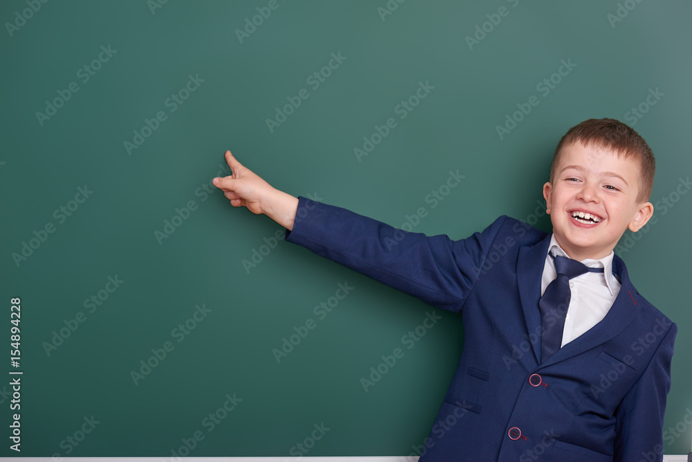 school boy point the finger near blank chalkboard background, dressed in classic black suit, group pupil, education concept school boy point the finger near blank chalkboard background, dressed in classic black suit, group pupil, education concept