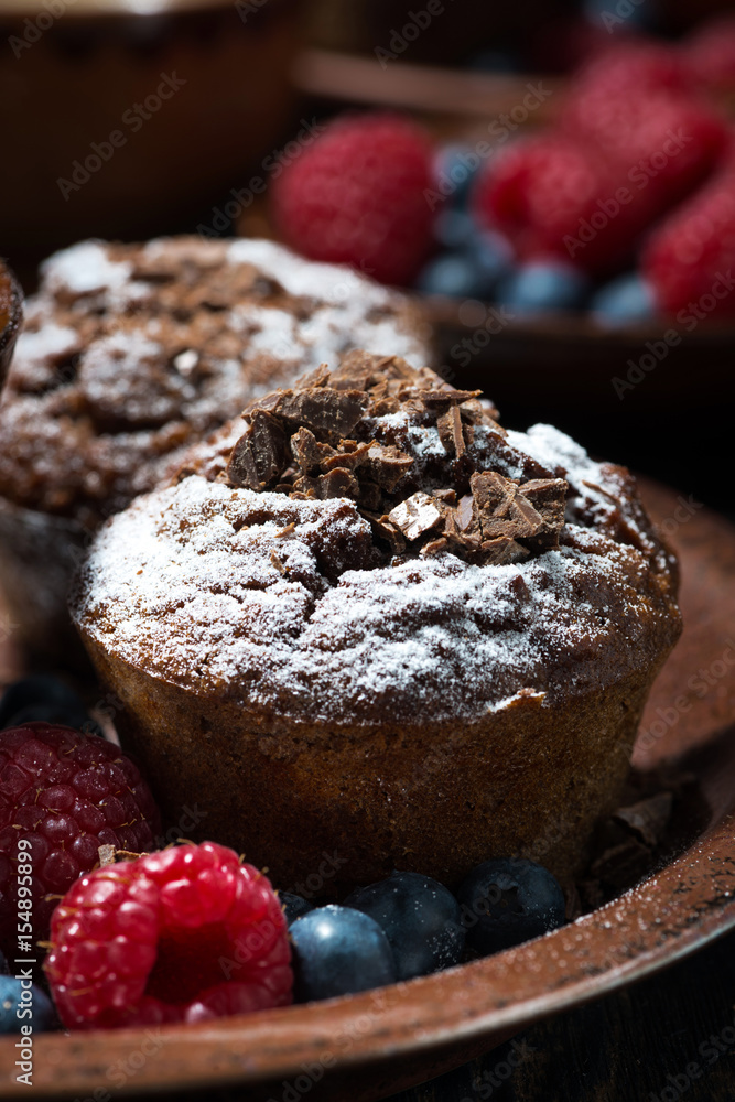 chocolate muffins and fresh berries for dessert, vertical closeup chocolate muffins and fresh berries for dessert, vertical closeup