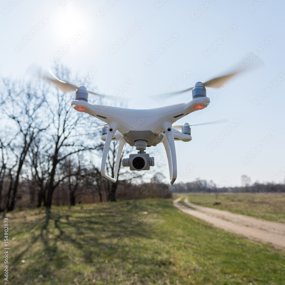 Copter soars from the ground to the sky against a background of green grass on the field. A drone with a high-resolution camera. Copter soars from the ground to the sky against a background of green grass on the field. A drone with a high-resolution camera.