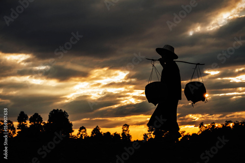farmer is walking at sunset.