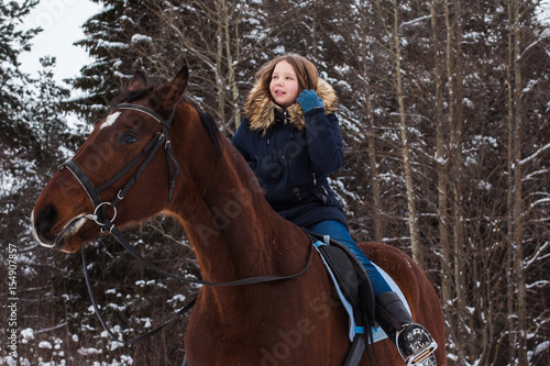 Girl teenager and big horse in a winter © keleny
