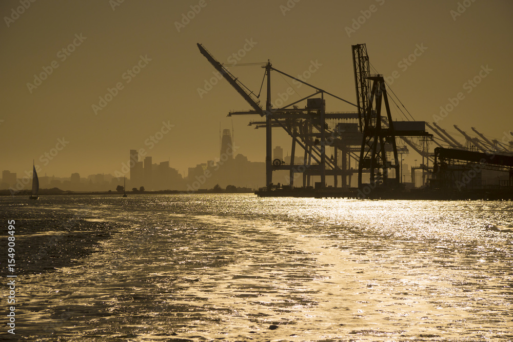 USA - California - San Francisco - Artificial panorama of silhouettes of gantry cranes of Alameda (Oakland) port with San Francisco skyline on background at dawn contre-jour
