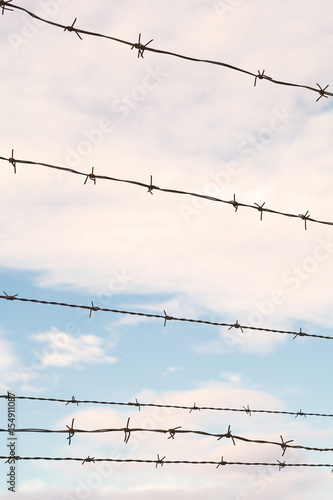 Barbed wire against blue sky.