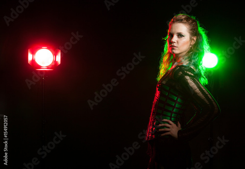 Cosplay model in corset in studio photo with a red and green light from behind. Cosplay and subculture