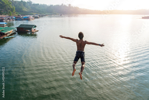 Man jumping into lake retro on Longest wooden bridge in sangkhlaburi Thailand