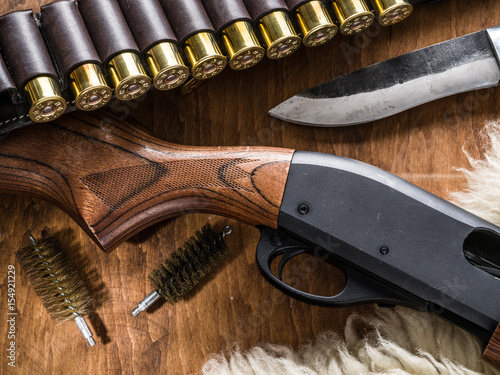 Pump action shotgun, cartridge 12 guage and hunting knife.