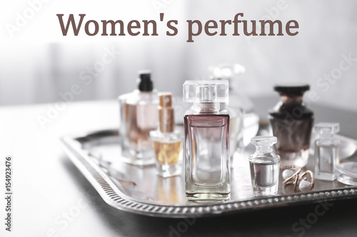 Women's perfume. Tray with bottles of scent on table