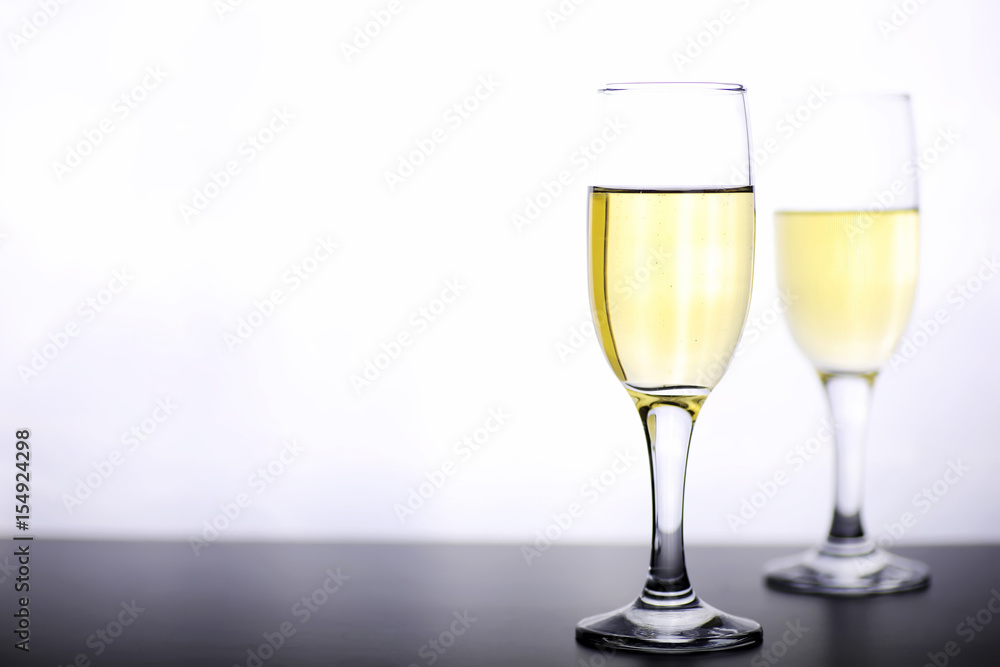 glass of white wine on a table on white background isolate glass of white wine on a table on white background isolate