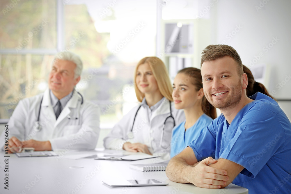 Team of doctors sitting at table in clinic Team of doctors sitting at table in clinic
