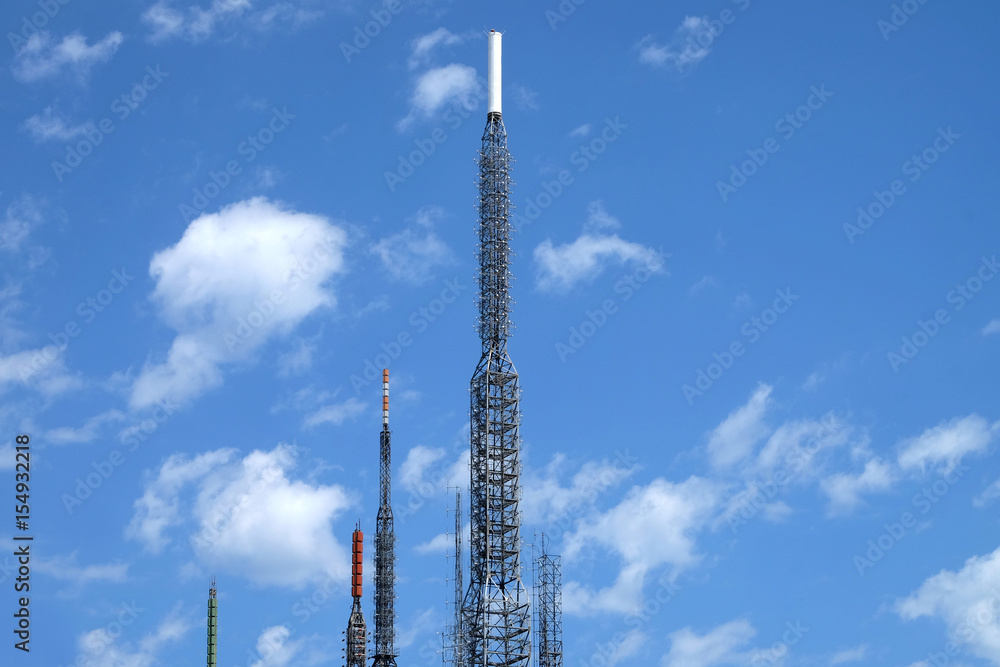 Big antenna towers for radio signal broadcasting in cloudy blue sky Big antenna towers for radio signal broadcasting in cloudy blue sky