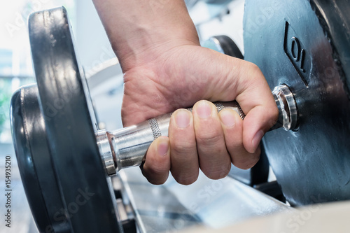 Closeup strong hand holding dumbbell