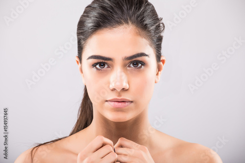 Tableau sur toile Pretty girl with big eyes and dark eyebrows, with naked shoulders, looking at ca