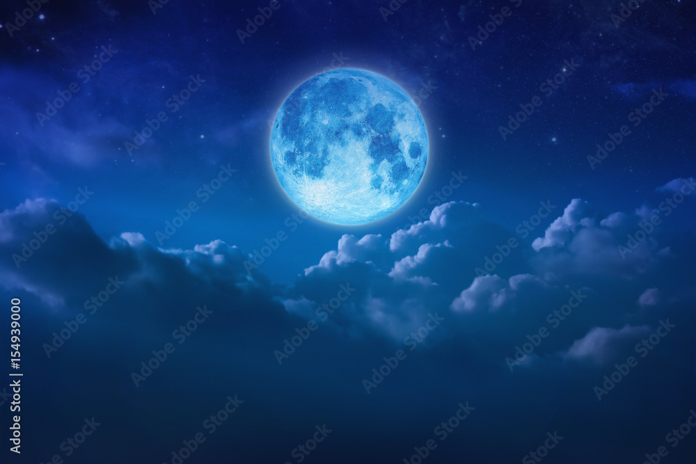 Fototapeta premium Beautiful blue moon behind cloudy on sky and star at night. Outdoors at night. Full lunar shine moonlight over cloud at nighttime with copy space background for headline text and graphic design.