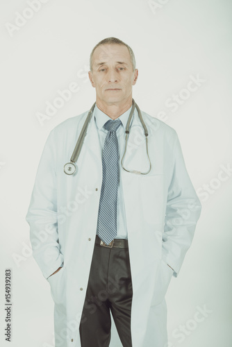 Male doctor with hands in pockets photo