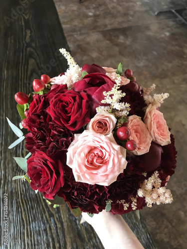 red bridal bouquet in girls hand