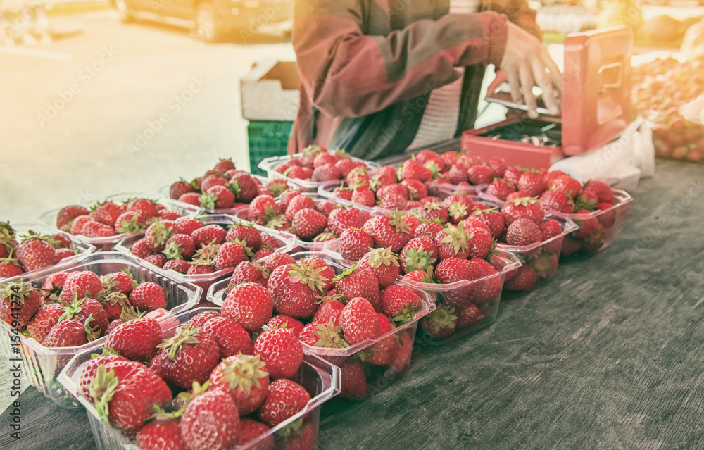 Beautiful ripe strawberries to sell on the tray in plastic containers in Norway on a Sunny day. The horizontal frame.