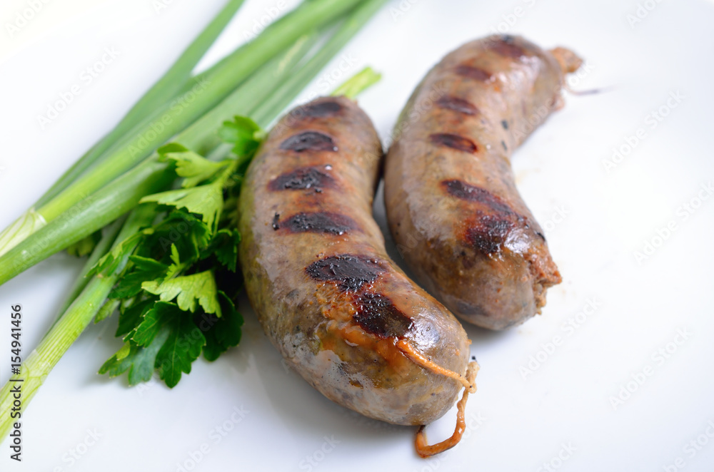 Grilled homemade liver sausage on white plate Grilled homemade liver sausage on white plate