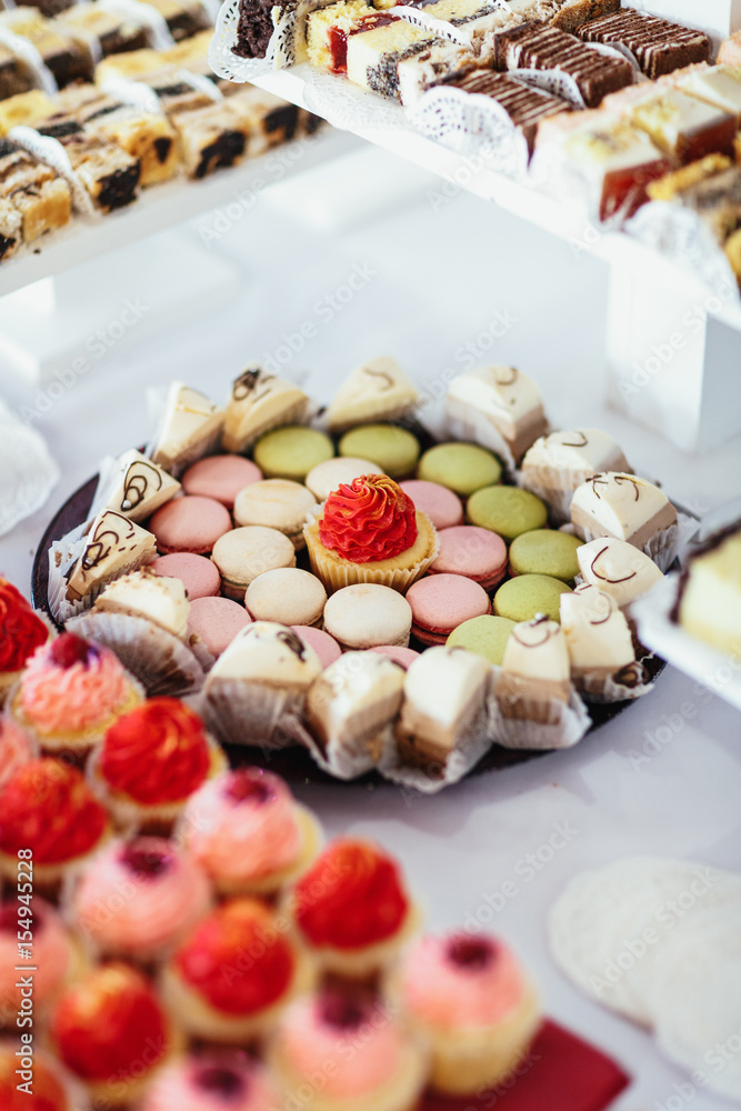 The pink macaroons and cakes standing on the banquet table The pink macaroons and cakes standing on the banquet table