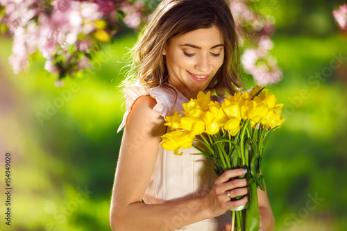 beautiful young girl with a bouquet of yellow tulips. Good spring mood. 
