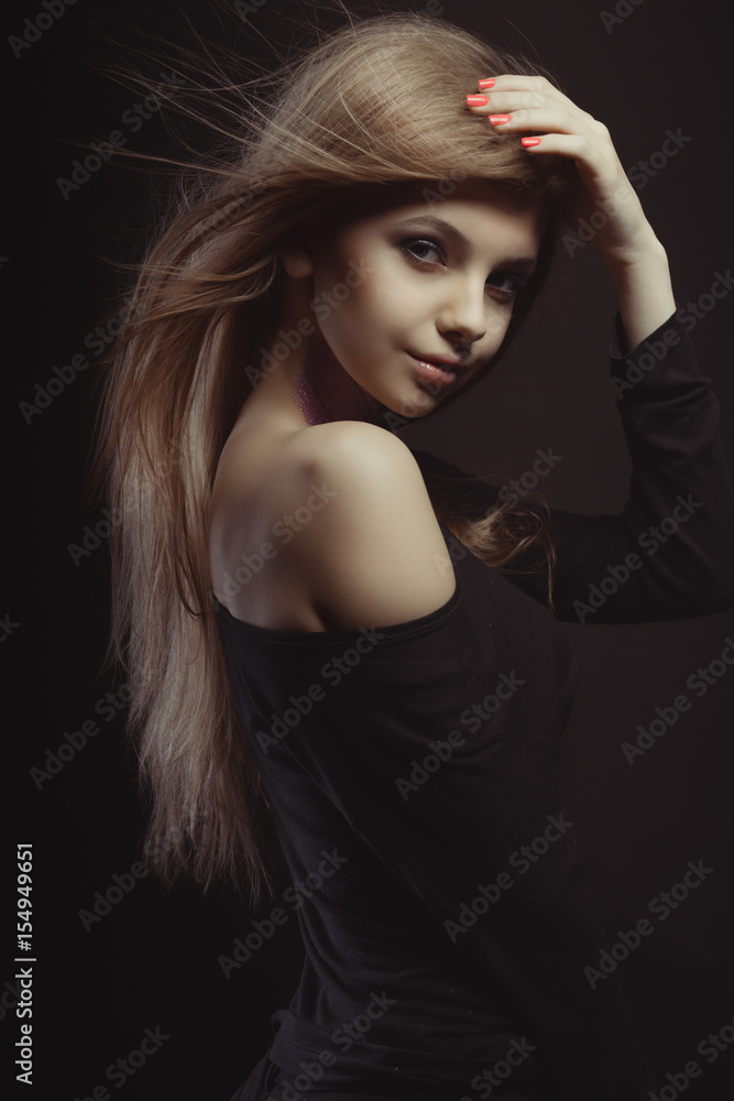 Attractive young woman with glitter on her neck and wind blowing her hair