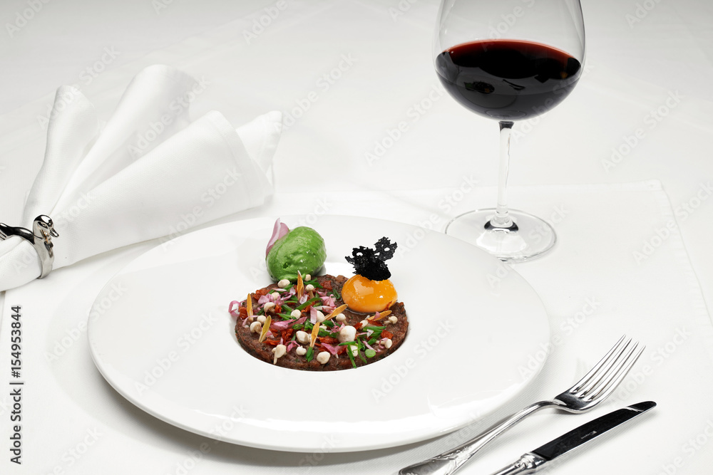 Veal tartar and wine in a restaurant Veal tartar and wine in a restaurant