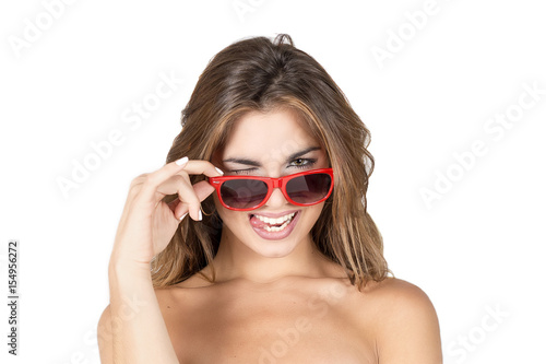 Beautiful young woman with blond hair and red sunglasses with funny face © Esteban