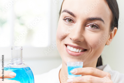 Foto Portrait Of Woman With Beautiful Teeth Using Mouthwash In Bathroom