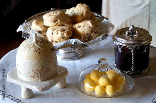 Butter, jam pot and honey pot ready to be spread on fresh scones for a traditional English cream tea