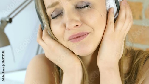 Smudged girl crying while listening music on headphones, steadycam shot
