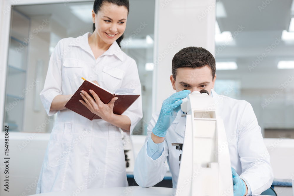 Obraz premium Attractive brunette keeping notebook on left hand