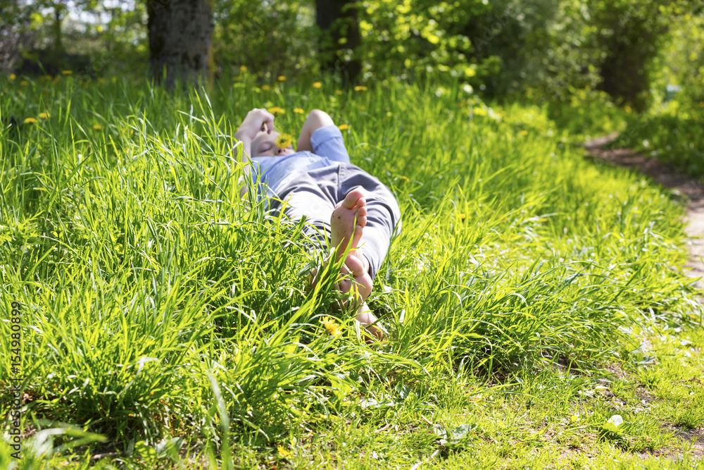 Boy lie on the grass on sunny day Boy lie on the grass on sunny day